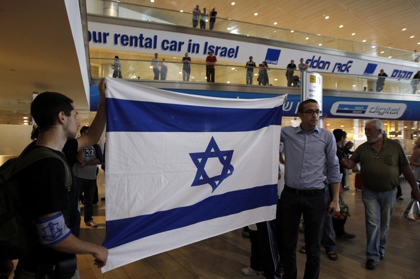 Right-wing activists hold an Israeli flag in the arrival hall at Ben Gurion International Airport near Tel Aviv April 15, 2012. A pro-Palestinian "fly-in" to Tel Aviv got off to a slow start on Sunday after Israel scrambled to block activists from boarding flights in Europe. REUTERS/Ronen Zvulun
