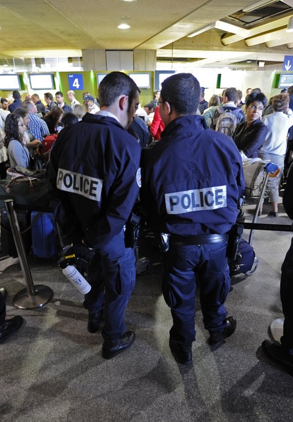 French police stand guard as passengers queue next to a check-in counter at Charles-de-Gaulle airport in Roissy near Paris July 8, 2011. A Hungarian airline stopped dozens of French activists heading for a pro-Palestinian "fly-in" in Israel from boarding a plane in Paris on Thursday. Some 600 people from around Europe, of which roughly 350 are from France, are trying to visit the city of Bethlehem at the invitation of a Palestinian group in an operation dubbed "Welcome to Palestine".       REUTERS/Gonzalo Fuentes