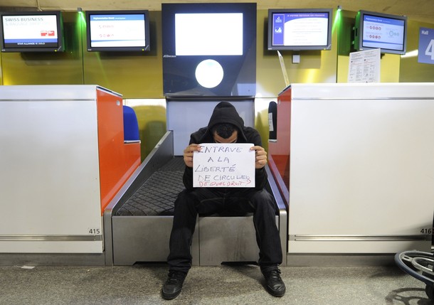 A man holding a sign which reads "Hindrance to free movement. On what grounds?" sits at a check-in counter at Charles-de-Gaulle airport in Roissy near Paris July 8, 2011. A Hungarian airline stopped dozens of French activists heading for a pro-Palestinian "fly-in" in Israel from boarding a plane in Paris on Thursday. Some 600 people from around Europe, of which roughly 350 are from France, are trying to visit the city of Bethlehem at the invitation of a Palestinian group in an operation dubbed "Welcome to Palestine".       REUTERS/Gonzalo Fuentes