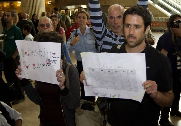 Israeli left-wing activist take part in a "Welcome to Palestine" fly-in at Ben Gurion airport near Tel Aviv on April 15, 2012 as hundreds of Israeli police, many undercover, were stationed at the airport to block the arrival of pro-Palestinian activists. Israel vowed to prevent entry  of activists, warning foreign airlines they would be forced to foot the bill for the activists' immediate return home in a move which saw many carriers toeing the line, prompting a furious response from passengers. AFP PHOTO/JACK GUEZ