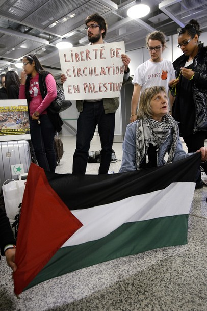 Pro-Palestinian activists hold a placard reading "freedom of circulation in Palestine" and a Palestinian flag as they protest at Geneva airport on April 15, 2012 in Geneva. Several dozen pro-Palestinian activists protested at Geneva airport, saying authorities prevented them from boarding a Tel Aviv-bound flight as part of a "fly-in" that Israel has vowed to block.    AFP PHOTO/ FABRICE COFFRINI